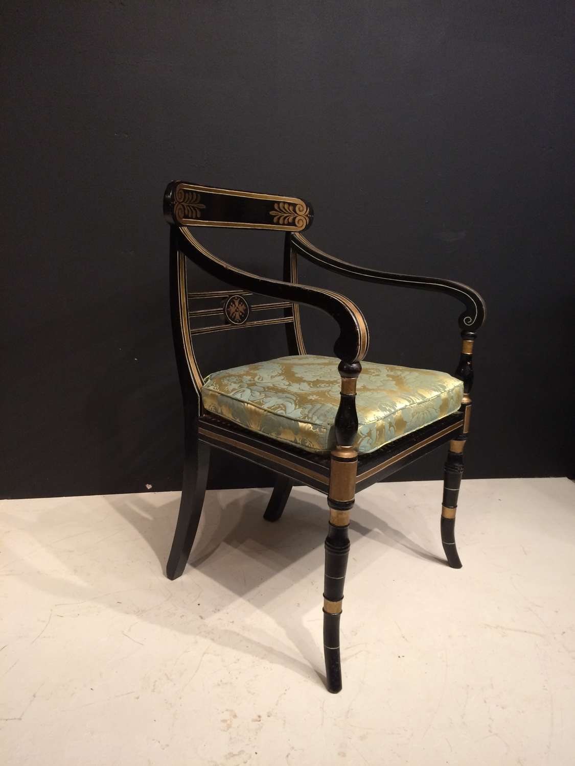 Regency black and gilt painted armchair.